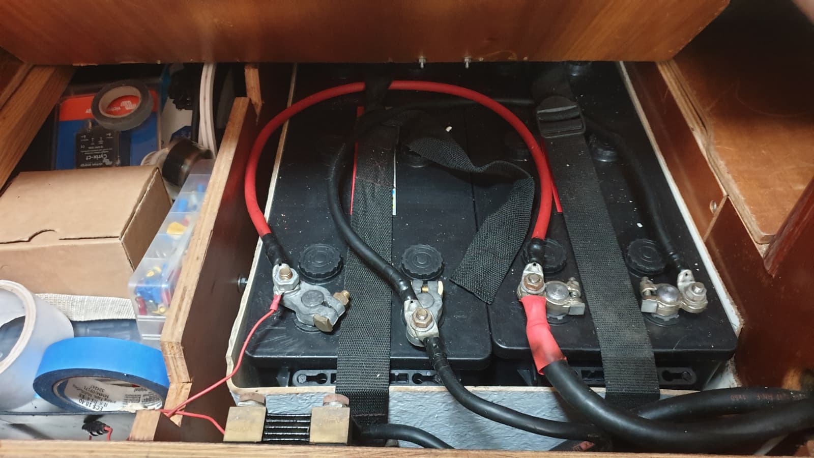 Batteries neuves (2026), dans une trappe dédiée sous le lit de la cabine tribord